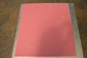 Roll out a sheet of pink fondant and use the stencil to cut out a side of it.