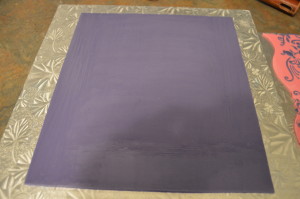 Roll out a slightly larger sheet of purple fondant and transfer the pink fondant on it.