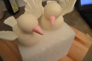 Make beaks out of pink fondant and stick to the heads. Also make eyes out of black fondant or use small black sugar pearls. Leave the doves to dry before using